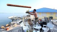 A man throws wood off the deck of a destroyed house following Hurricane Irma in Little Torch Key, Florida, U.S., September 20, 2017. REUTERS/Carlo Allegri
