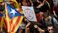 Students hold a Catalan pro-independence 'esteladas' flag and a cartoon depecting Spanish Prime Minister Mariano Rajoy gather in front of the historical headquarters of the University of Barcelona during a pro-referedum demonstration on September 22, 2017