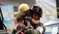 A girl hugs a Mexican marine officer as she offers hugs to people near the site of a collapsed building after an earthquake, in Mexico City, Mexico September 23, 2017. REUTERS/Jose Luis Gonzalez
