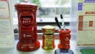 ost box shaped piggy banks (L and C) and a penholder are seen at a post office of Japan Post Co in Tokyo, Japan, November 2, 2015. REUTERS/Toru Hanai