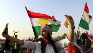 A Syrian Kurd takes a selfie, in the northeastern Syrian city of Qamishli on September 26, 2017, during a gathering in support of the independence referendum in Iraq's autonomous northern Kurdish region. / AFP / Delil souleiman