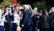 US President Donald Trump tosses a hat to supporters as he departs for Bedminster, New Jersey, from the White House in Washington, U.S., September 29, 2017. Reuters/Joshua Roberts 
