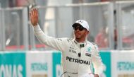 Mercedes’ Lewis Hamilton waves after getting pole position in qualifying. REUTERS/Edgar Su
