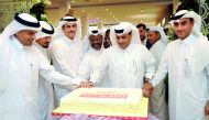 Sheikh Dr Khalid bin Thani bin Abdullah Al Thani (third left), Chairman and Managing Director, QIIB; Dr Abdulbasit Ahmed Al Shaibei (left), CEO, along with other officials and guests cutting a cake to mark the opening of the bank’s branch at Doha Festival