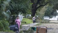 Biloxi residents venture out just after dawn to survey the damage after the eye of Hurricane Nate made its second landfall on October 8, 2017 in Biloxi, Mississippi.  Mark Wallheiser/AFP

