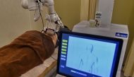 In this photo taken on October 12, 2017, a robot masseuse performs a massage on patient Elaine Low, 35, at the NovaHealth traditional chinese medicine (TCM) clinic in Singapore. AFP / ROSLAN RAHMAN 