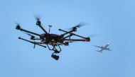 FILE PHOTO: A drone flies as an airplane is seen in the background during a press presentation of Swiss disaster dog association Redog on combined search and rescue outside Zurich on August 23, 2017 (AFP / Fabrice Coffrini) 