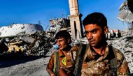 Members of the Syrian Democratic Forces (SDF), backed by US special forces, check the area near Raqa's stadium as they clear the last positions on the frontline on October 16, 2017 in the Islamic State (IS) group crumbling stronghold. AFP / BULENT KILIC
