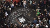 This file photo taken on September 01, 2017 shows people surrounding a portrait painted on the street of Santiago Maldonado --disappeared on August 1st during a Mapuche protest in Chubut province-- during a demonstration called by human rights association