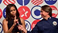 This file photo taken on June 17, 2015 shows former US First Lady Michelle Obama (L) speaking next to US Chef John Besh at the James Beard American Restaurant during a visit in Milan. AFP / Giuseppe Cacace