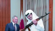 Emir admires a gun as the Russian Defence Minister looks on. 