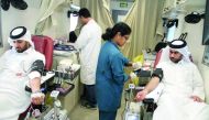 Employees donating blood aboard an HMC mobile vehicle in front of Kahramaa  headquarters in West Bay, yesterday.