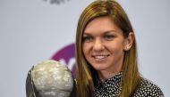 Simona Halep of Romania poses with her WTA year-end world number one trophy during the WTA Finals tennis tournament in Singapore on October 29, 2017. / AFP / ROSLAN RAHMAN
