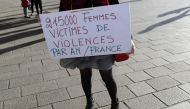 A woman holds a placard reading '21500 women victims of violence per year in France' as people gather for a rally at the Old Port of Marseille, southern France, on October 29, 2017, to denounce harassment and sexual violence in everyday life. Hundreds of 