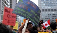 This file photo taken on June 24, 2010 shows a woman holding a sign as several hundred indigenous people march through the streets of Toronto to bring attention to the plight of indigenous peoples in Canada two days prior to the opening of the G20 Summit 