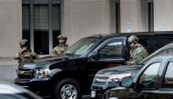 US Marshals wait to company an armored vehicle with Mustafa al-Imam as it leaves after a hearing at the US District Court on November 3, 2017, in Washington, DC. AFP / Brendan Smialowski
