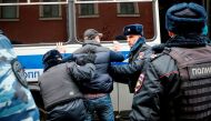 Russian police search an opposition activist during a protest rally in central Moscow on November 5, 2017.   AFP / Maxim ZMEYEV
