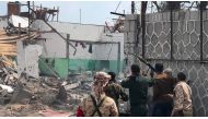 Yemeni men and security forces inspect the site of a suicide bombing in the southern port city of Aden, on November 5, 2017. AFP

