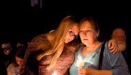 Local residents embrace during a candlelight vigil for victims of a mass shooting in a church in Sutherland Springs, Texas, U.S., November 5, 2017. REUTERS/Mohammad Khursheed