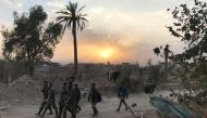 Syrian government forces walk through a road in a northeastern district of Deir Ezzor on November 5, 2017, after retaking the city from Islamic State (IS) group jihadists.  AFP / STRINGER
