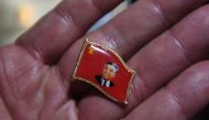 A Chinese vendor displays a pin with an image of North Korean founder Kim Il Sung in the border city of Dandong in China's northeast Liaoning province on September 3, 2017 (AFP / Greg Baker) 
