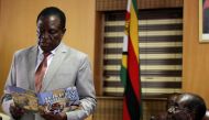 FILE PHOTO: Zimbabwe's President Robert Mugabe looks on as his deputy Emmerson Mnangagwa reads a card during Mugabe's 93rd birthday celebrations in Harare, Zimbabwe, February 21, 2017. Reuters/Philimon Bulawayo
