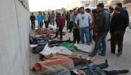 People gather next to bodies following a reported airstrike on the rebel-held town of Atareb in Syria's northern Aleppo province on November 13, 2017. AFP / Zein Al Rifai