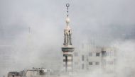 Smoke covers buildings following an air strike on the rebel-held besieged town of Arbin, in the Eastern Ghouta region on the outskirts of Damascus, on November 18, 2017. / AFP / Amer ALMOHIBANY