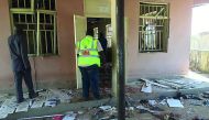 A National Emergency Management Agency (NEMA) staff inspects the damage at the site of a suicide bomber attack in Mubi in Adamawa state, yesterday.
