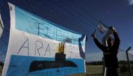 A man hangs an Argentinian flag outside Argentina's Navy base in Mar del Plata, on the Atlantic coast south of Buenos Aires, on November 22, 2017. AFP / EITAN ABRAMOVICH
