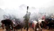 People fall as police fire tear gas to try control a crowd trying to force their way into a stadium to attend the inauguration of President Uhuru Kenyatta at Kasarani Stadium in Nairobi, Kenya November 28, 2017. REUTERS.