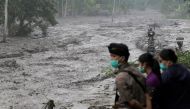 Villagers watch a river overflowing with water mixed with volcanic ash during the eruption of Mount Agung in Karangasem, Bali, Indonesia November 28, 2017. REUTERS/Johannes P. Christo
