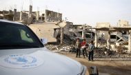 Boys stand next to debris of damaged buildings in the town of Nashabiyeh, eastern Ghouta in Damascus, Syria, November 28, 2017. REUTERS/Bassam Khabieh