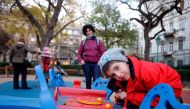 Aron (R) looks into the camera, at a local playground in Budapest on November 22, 2017. AFP / Peter Kohalmi  