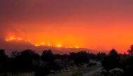 The Thomas Fire burns behind trails on Old Baldwin Road in Ojai, California on December 6, 2017. / AFP.