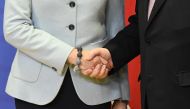 British Prime Minister (L) shakes hands with European Commission President at the European Commission in Brussels on December 8, 2017. (AFP / EMMANUEL DUNAND)