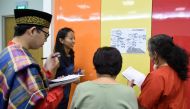 This photograph taken on October 19, 2017 shows students from various cultures in a group discussion during their Kristang language class session at the national library board in Singapore. / AFP.