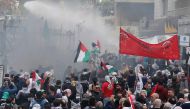 Protesters are sprayed with water near the U.S. embassy in Awkar east of Beirut, Lebanon December 10,2017. REUTERS/Mohamed Azakir.