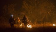 Firefighter set a backfire to make progress against the Thomas Fire before the winds return with the daylight near Lake Casitas on December 9, 2017 near Ojai, California. / AFP.