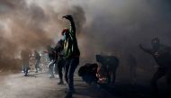 Palestinian protesters clash with Israeli troops near an Israeli checkpoint in the West Bank city of Ramallah on December 8, 2017.  AFP / ABBAS MOMANI