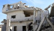 A man is seen on the rubble of damaged buildings in the rebel-held area, in the city of Deraa, Syria December 12, 2017. REUTERS/Alaa al-Faqir.