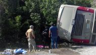Mexican police officers and paramedics work in the scene of a road accident, where a bus driving tourists to Chacchoben archaeological zone overturned between El Cafetal and Mahahual, in Quintana Roo state, Mexico on December 19, 2017. / AFP.