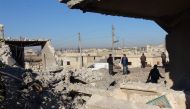 Residents inspect the debris of buildings after the airstrikes over Jarjanaz District of Idlib in Syria on December 26, 2017. Muaz Yemen - Anadolu