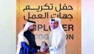 Ali Hamad Al Mesaifri (right), Chief of Human Resources and General Services at QIIB, receives a memento from Dr Hassan Rashid Al Derham, President, Qatar University.