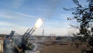A Syrian rebel fighter belonging to the US-backed Mutasem brigades fires an anti-aircraft gun mounted on the back of a pickup truck as he receives heavy weapons training near the rebel-held village of Shamarin in the north of Aleppo province, on December 