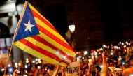 This file photo taken on October 17, 2017 shows people holding candles and a Catalan pro-independence 'Estelada' flag during a demonstration in Barcelona against the arrest of two Catalan separatist leaders. / AFP.