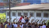 This photo released by Brazilian newspaper O Popular shows prisoners' relatives waiting for information outside the 