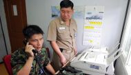 This file photo taken on August 10, 2005 shows South Korean Lieutenant Choi Don-Rim (L) communicating with a North Korean officer during a phone call at a military office near the Demilitarised Zone (DMZ), separating North and South Korea, in Paju, north 