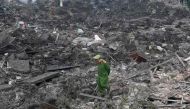 A policeman walks across debris after a big explosion razed five homes and shattered windows of surrounding buildings in the northern province of Bac Ninh on January 3, 2018. / AFP / HOANG DINH NAM