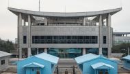 In a photo taken on November 30, 2016 North Korean People's Army (KPA) soldiers stands guard before the military demarcation line and 'Peace House', proposed as the venue of upcoming talks between North and South Korea, at the truce village of Panmunjom i